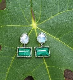 With their earthy elegance and vibrant combination of colors, these earrings also add a playful sophistication to any collection. The slightly domed malachite and faceted rainbow moonstone are framed by sparkling tsavorite stones. As casual or as dressy as you like, these earrings exude a playful, sophisticated style. Total length : 30mm malachite stone : 15mm x 12mm You might also like: https://www.etsy.com/listing/649858864/diamond-eearrings-crystal-quartz-and?ref=shop_home_active_22 Wear thes Elegant Green Earrings With Natural Stones, Green Natural Stone Earrings For Wedding, Green Natural Stones Earrings For Wedding, Fusion Green Earrings With Natural Stones, Green Natural Stones Fusion Earrings, Green Fusion Earrings With Natural Stones, Green Natural Stone Fusion Earrings, Green Multi-stone Drop Earrings, Green Drop Earrings With Gemstone Accents