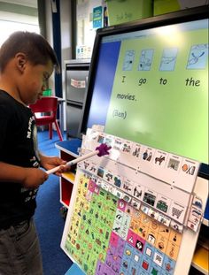 a young boy standing in front of a large poster with words and pictures on it