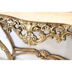 an ornate gold console table with marble top