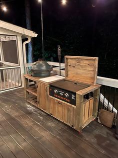 an outdoor bbq grill on a deck at night