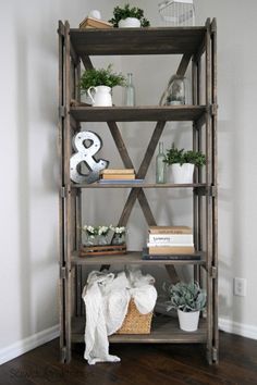 a wooden shelf with plants and books on it