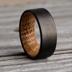 a wooden ring with black ceramic inlay