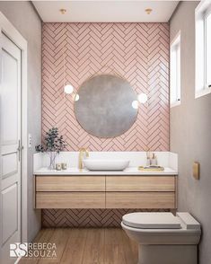 a bathroom with pink and white tiles on the wall, wood flooring and a round mirror