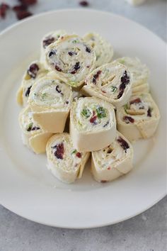 a white plate topped with rolls covered in cranberry sauce and cream cheese frosting