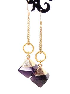 Clip-on style also available! These unique dangle stone earrings make a stunning statement! Semi precious Amethyst stone pendants coupled with 10k gold plated textured rings give these beauties a chic look with a luxurious feel! 18k gold plated wire earring hooks add a delicate touch, completing the earrings!Product De 14k Gold Filled Jewelry With Gemstone Accents, Amethyst Gemstone Drop Earrings With Accents, Elegant 14k Gold-filled Jewelry With Gemstone Accents, Gold Plated Drop Earrings With Gemstone Accents, Gold Plated Dangle Jewelry With Gemstone Accents, Amethyst Dangle Jewelry With Natural Stones, Amethyst Natural Stones Dangle Jewelry, Modern Long Drop Gemstone Jewelry, Gold Dangle Jewelry With Gemstone Accents