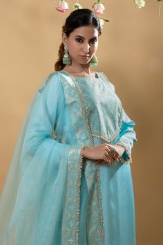 Blue silk satin straight kurta with floral brocade pattern bodice with crystal embellishments. Paired with a pant and matching dupatta with brocade pattern border.
Components: 3
Pattern: Brocade
Type Of Work: Quatrefoil
Neckline: Round Neck
Sleeve Type: Full Sleeves
Fabric: Silk Satin
Color: Blue
Other Details: 
Attached inner lining
Pearl embellishments on dupatta
Occasion: Sangeet - Aza Fashions Brocade Pattern, Kurta Pant Set, Straight Kurta, Satin Color, Kurta With Pants, Fabric Silk, Blue Silk, Full Sleeves, Crystal Embellishment