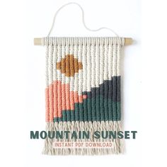 the mountain sunset wall hanging is made with macrame yarn and wood beads, along with a wooden hanger