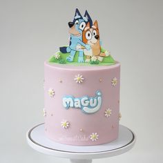 a pink cake with cartoon characters on top