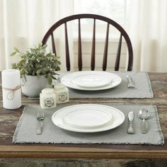 the table is set with white plates and silverware