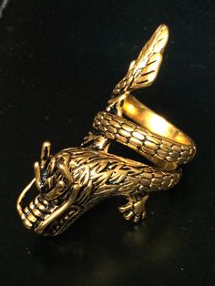 This is a perfect and unique style magic ring made of brass metal by ring guru. The power of the ring is to protect all dangers including ghost, evils and devils and the ring can bring good luck, fortune and wealth to the wearer. The ring showcases an elegant design with unique holy amulet. It is great to get this ring for your loved one or treat yourself for a classic timeless style. Amulet Name: Powerful Dragon Ring Ring Story : The dragon or 龙 is one of the divine animals of China, which represents auspiciousness, greatness, virtue and goodness. The Chinese also believe that dragons can ascend to heaven and descend to the ocean, and can also bring rain. Therefore, Chinese farmers have a tradition of worshiping the dragon god to bring rain in season, helping crops to grow well. Ring Size Dragon Rings, Gold Jewelry With Dragon Design, Spiritual Gold Jewelry With Dragon Design, Gold Dragon Jewelry, Adjustable Dragon Design Ring, Luxury Gold Dragon Design Jewelry, Dragon Ring, Timeless Classic Style, Magic Ring