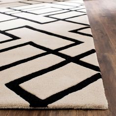 a black and white rug on a wooden floor