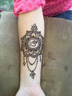 a woman's arm with a henna tattoo on it