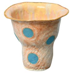 a ceramic vase with blue dots on the outside and inside of it's rim