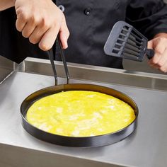 a person cooking omelette in a frying pan