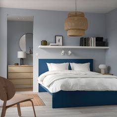 a bedroom with blue walls and white bedding