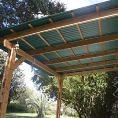 a wooden pergoline covered patio with trees in the background