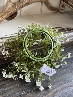 a bunch of white flowers sitting on top of a wooden table next to antlers