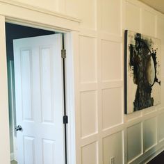 an open door leading to another room with white walls and wood flooring on the other side