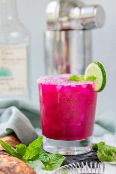 a pink drink with lime and mint garnish