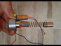 a person is holding an object with wires attached to it and the wire has green light coming out