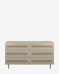 a beige dresser with two drawers and copper handles