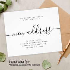 the new address card is on top of an envelope with greenery and gold foil