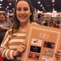 a woman holding up a board with pictures on it