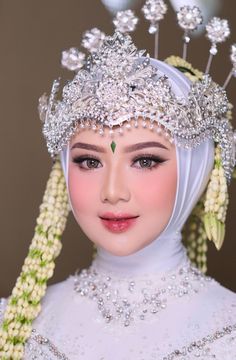 a woman wearing a white dress and headpiece