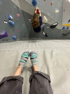 a person with their feet up on a climbing wall