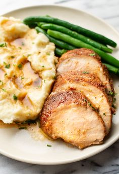 pork chops, mashed potatoes and green beans on a white plate