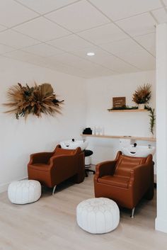 two brown chairs sitting next to each other on top of a hard wood floor in a room