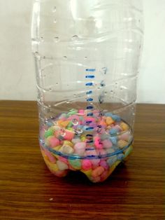 a plastic container filled with lots of different colored candy in it's bottom half