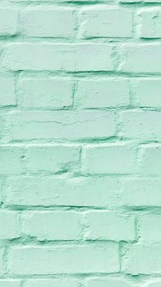 a green brick wall painted in pastel colors