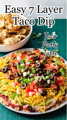 easy 7 layer taco dip recipe on a plate with tortilla chips