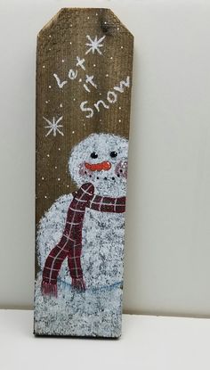 a wooden sign with a snowman painted on it