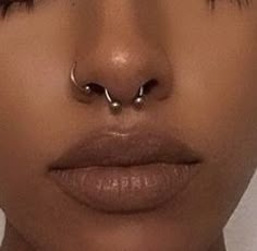 a woman's nose with two piercings on her nose and one in the middle