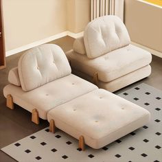 two white couches sitting next to each other on a rug