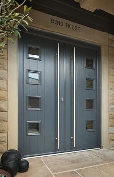 a pair of black shoes sitting in front of a gray door with glass inserts