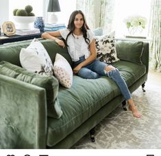 a woman sitting on top of a green couch