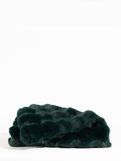 a dark green fur hat on a white background