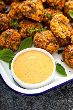 a white plate topped with meatballs and dipping sauce