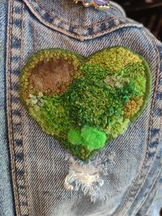 a heart shaped patch on the back of someone's jean jacket that has been sewn