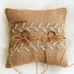 two decorative pillows made out of burlock and twine with leaves on them