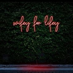 a neon sign that says wiley for aley on it's side next to a green wall