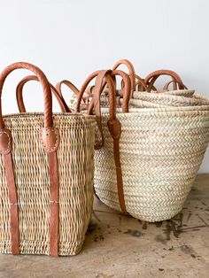 These hand woven straw bags are made in Morocco. Its perfect for the beach, a picnic or the farmers market. The natural straw color mixed with the warm tones of its leather handles makes it stylish while sturdy enough to carry just about anything. Measures Approx: Petit: 17"L x 11"H x 8"W Moyen: 22"L x 14"H x 12"W Grand: 24"L x 17"H x 12"W. Please note that due to the natural materials of this bag, colors and sizes may vary. French Market Bag, French Market Basket, French Life, Grocery Market, Preppy Bags, Braided Bag, French Baskets, Straw Basket, French Market