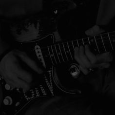 a person is playing an electric guitar in the black and white photo with their hands