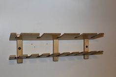 a wall mounted shelf with three wooden shelves on it's sides and four holes in the middle