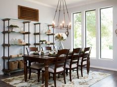 a dining room table with chairs and shelves on the wall