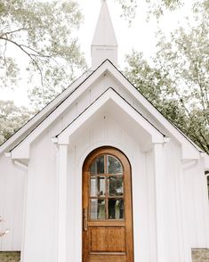 a white church with a wooden door and steeple