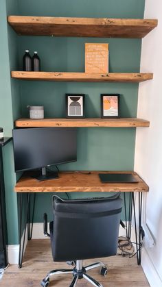 a desk with two computer monitors on top of it and some shelves above the desk